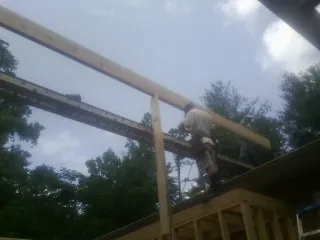 Carpenter setting a ridge beam over a new addition frame — Ice Dam Removal by Roofing Brothers in New Ulm
