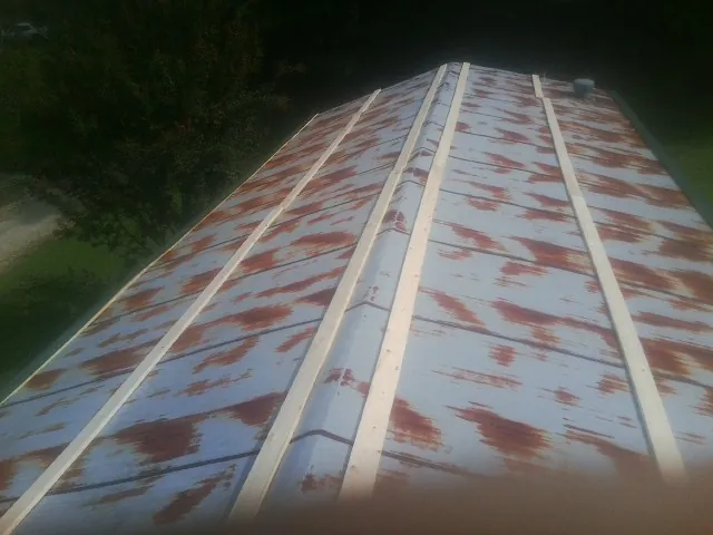 Rusted metal roof panels with new wood purlins before replacement — Storm Damage Roof Repair in New Ulm by Roofing Brothers